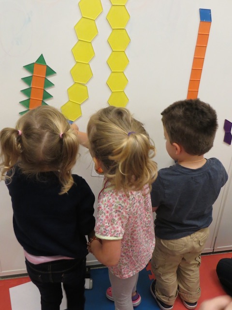 Children playing with tessellation tiles on white board