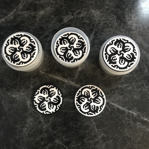 Five black-and-white, round, laser-cut decorations