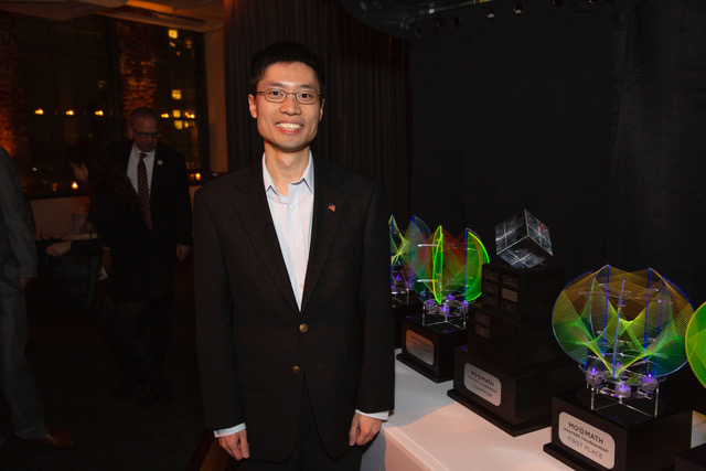 Po-Shen Loh standing next to trophies